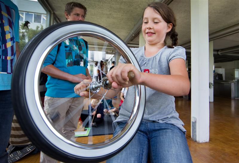 Kind mit Fahrradfelge auf dem Drehschemel